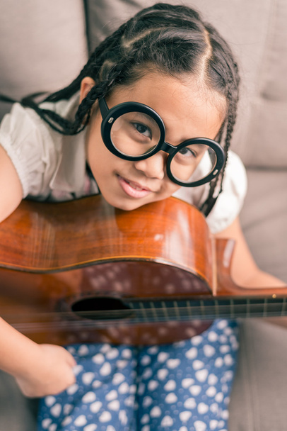 Boldog mosolygó lány tanulási játszani a gitár - Fotó, kép