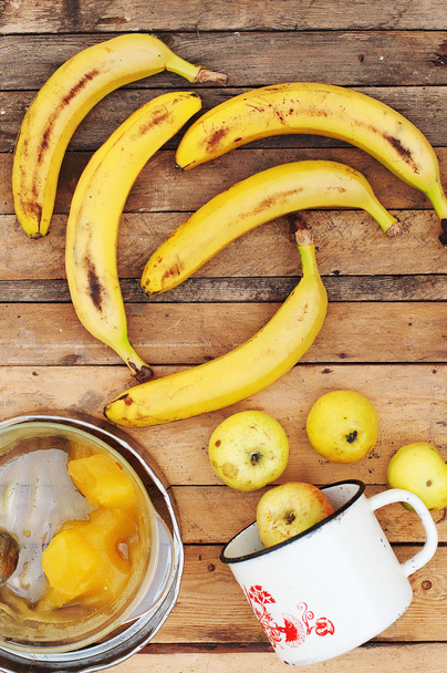 спелые желтые бананы в плетеной корзине, на деревянном фоне, вид
 - Фото, изображение