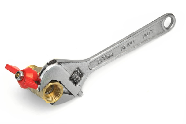 Шаровой клапан схвачен с регулируемым гаечным ключом, изолированным на белой спине
 - Фото, изображение