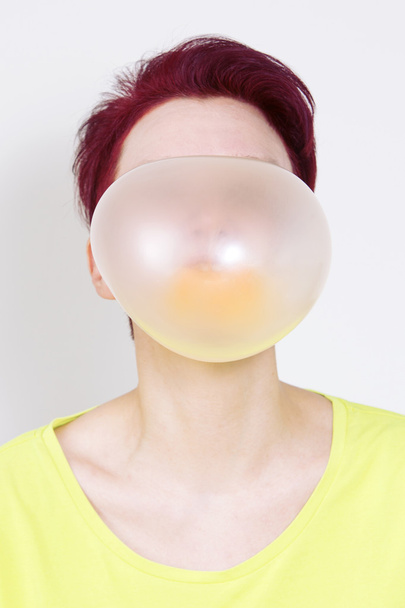 vrouw met grote gele luchtbel van kauwgom - Foto, afbeelding