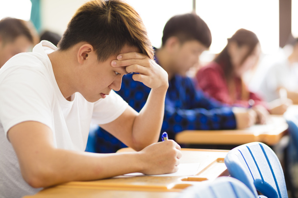 Stressed college student  for exam in classroom - Photo, Image