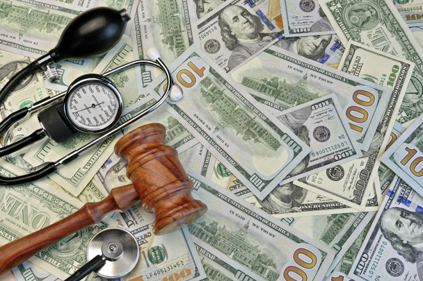 Судьи молоток и медицинские инструменты на долларовом фоне наличными
 - Фото, изображение