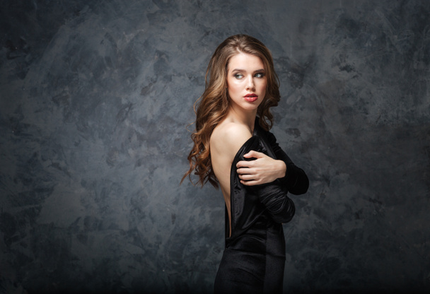 Beautiful tender young woman in black dress with open back  - Fotoğraf, Görsel