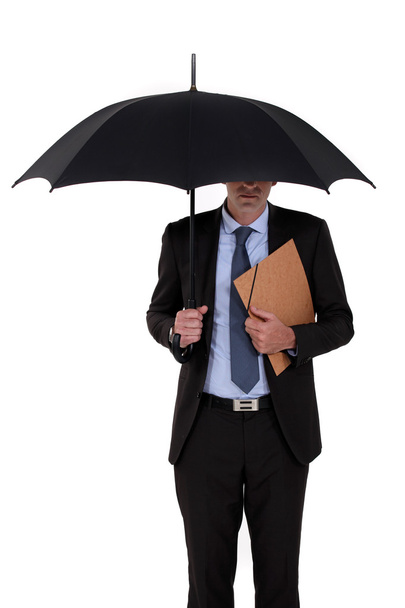 Businessman holding an umbrella - Фото, зображення