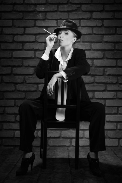 Woman smoking cigarette in mouthpiece in bar - Foto, imagen