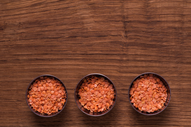 red lentils in metal bowl on brown table - Fotó, kép