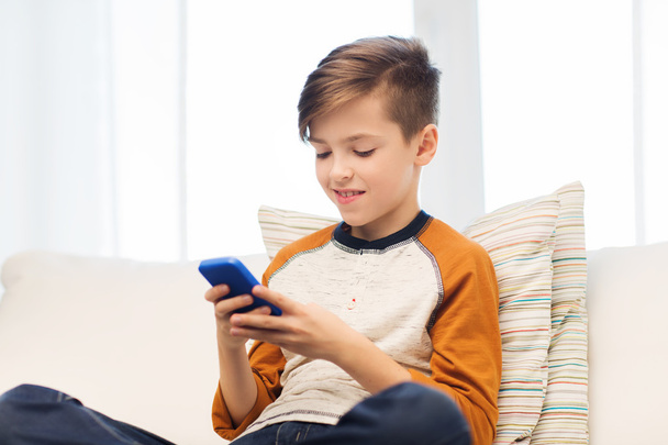 boy with smartphone texting or playing at home - Foto, imagen