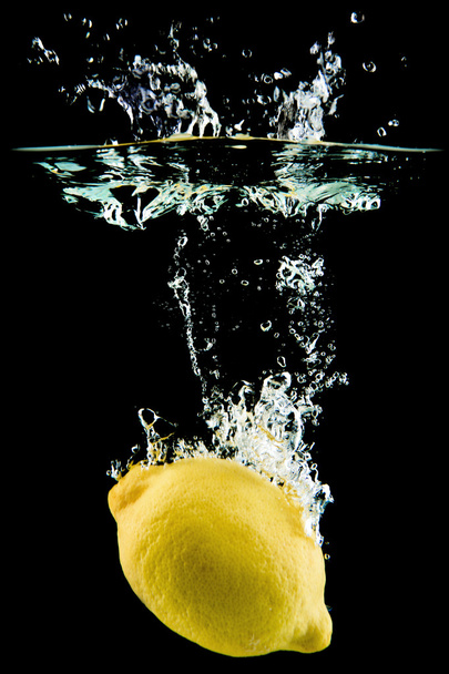 Lemon falling in the water - Фото, изображение