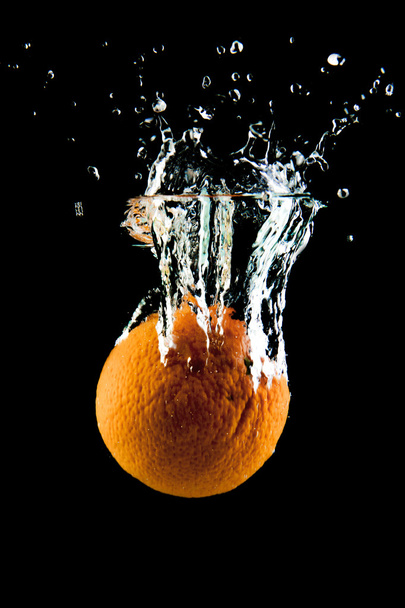 Orange falling in the water - Photo, Image