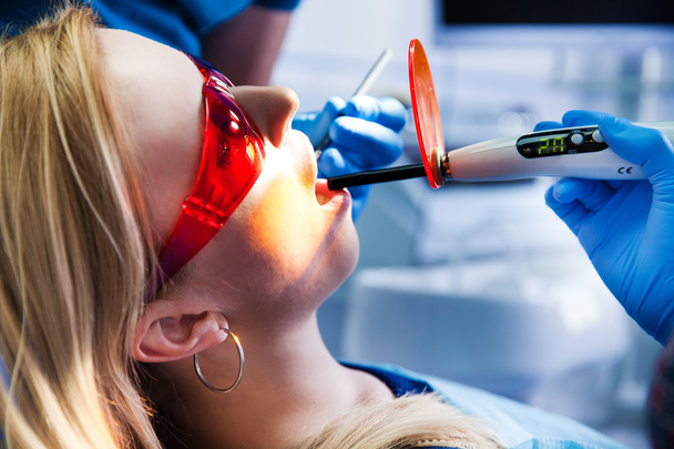 dentist treats teeth - Foto, afbeelding