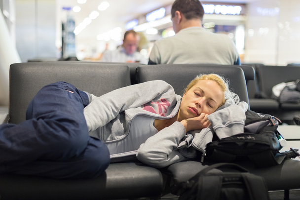 Mujer cansada viajera durmiendo en el aeropuerto
. - Foto, imagen