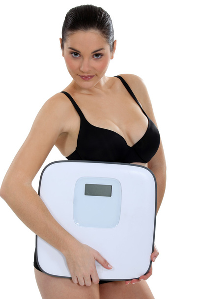 Woman in underwear carrying scales - Zdjęcie, obraz