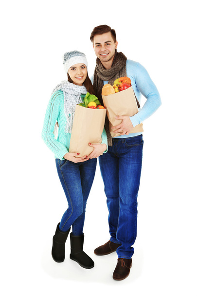 Young couple with paper bag of products isolated on white - Photo, Image