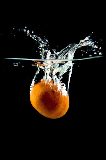 tangerine falling in the water - Photo, image