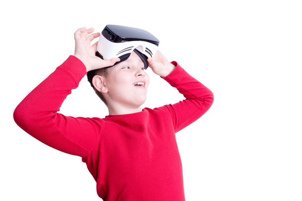 Child lifts up virtual reality headset to see - Foto, afbeelding