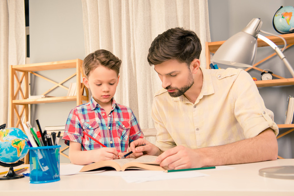 Jeune père aidant son petit fils à faire ses devoirs
 - Photo, image