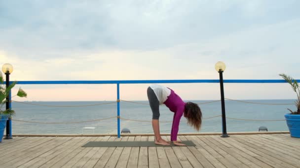 joven hembra practicando yoga en la terraza junto al mar
 - Imágenes, Vídeo
