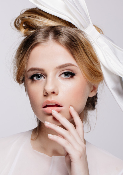 Portrait of young beautiful bridal with natural beauty, nude makeup, big white bow in the  hair - Foto, Imagem