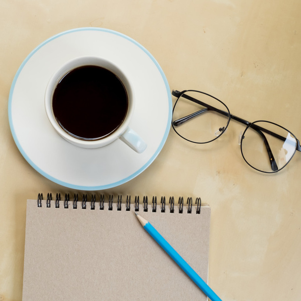 still life with notebook , pencil,  glasses and cup of coffee on - Fotoğraf, Görsel