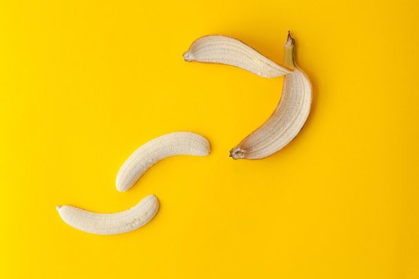Slupka banánů a ovoce na žlutém podkladu - Fotografie, Obrázek