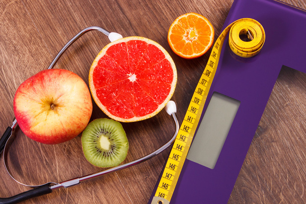 Electronic bathroom scale, centimeter and fresh fruits with stethoscope, slimming and healthy lifestyles - Foto, immagini