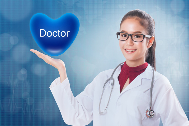 Kobieta lekarz trzymając serca znakiem lekarz medyczny. - Zdjęcie, obraz