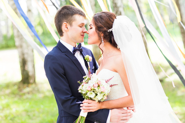 onu kucaklayan evlilik çift öpüşme, elinde bir buket çiçek, Gelin Damat - Fotoğraf, Görsel