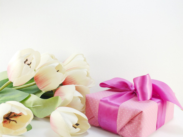 pink gift box present with white bow on pink polka dot background - 写真・画像