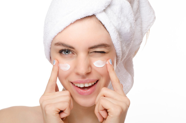 krásná mladá žena použití crème na její tváři izolovaných na bílém pozadí - Fotografie, Obrázek