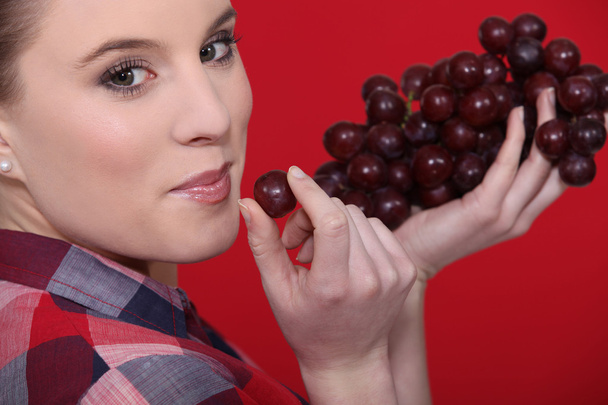 Woman eating grapes - Foto, afbeelding
