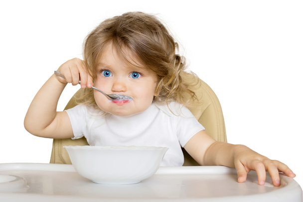 Baby eating baby food in high chair. - Photo, Image