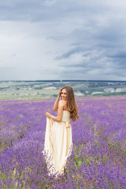 Pretty girl is walking at lavender field - Photo, Image