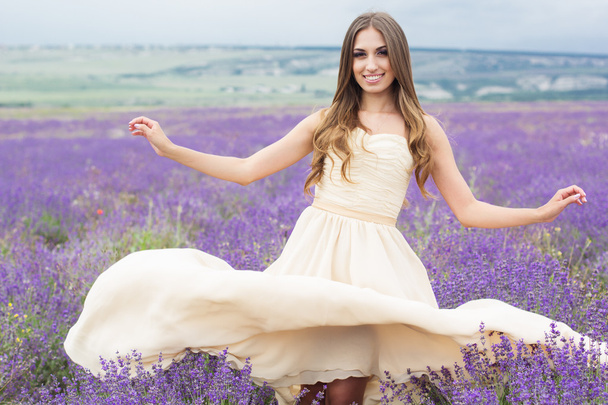Улыбающаяся девушка в летучем платье на лавандовом поле
 - Фото, изображение