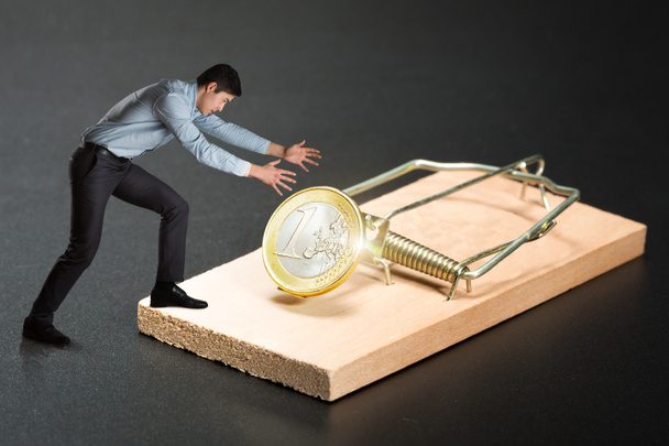 Бизнесмен с золотой монетой в мышеловке
 - Фото, изображение