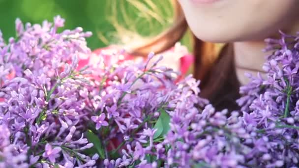 屋外の手でライラックの花の花束と美しい笑顔の若い女性 - 映像、動画