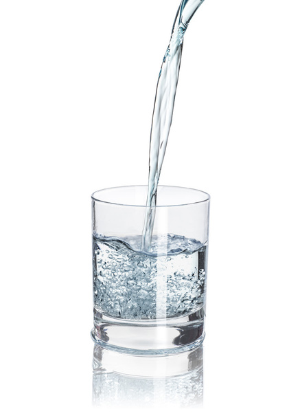 pour water into the half-full glass with reflection isolated on  - Foto, Imagen