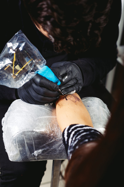 Brunetka tattooist robi tatuaż - Zdjęcie, obraz