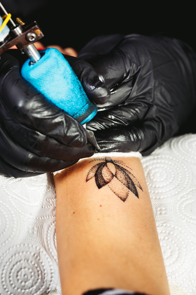 Maestro del tatuaje está mostrando el proceso de creación de un tatuaje
 - Foto, Imagen