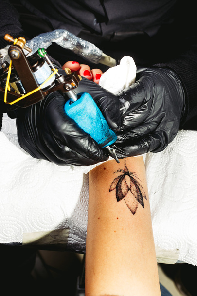 Tatuaje artista dibuja una flor de loto
 - Foto, Imagen