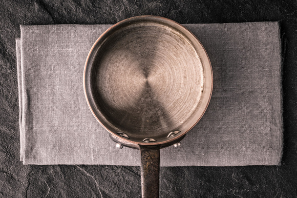 Metal pan on the dark stone table top view - Foto, Bild