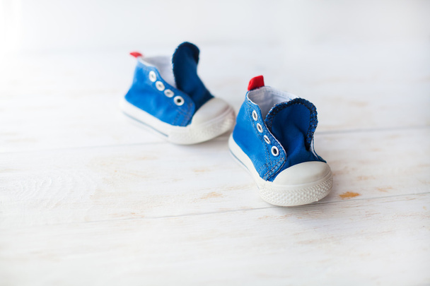 blue baby sneakers on a wood floor - Photo, Image