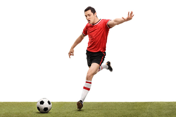 Young football player kicking a ball  - Foto, Imagen
