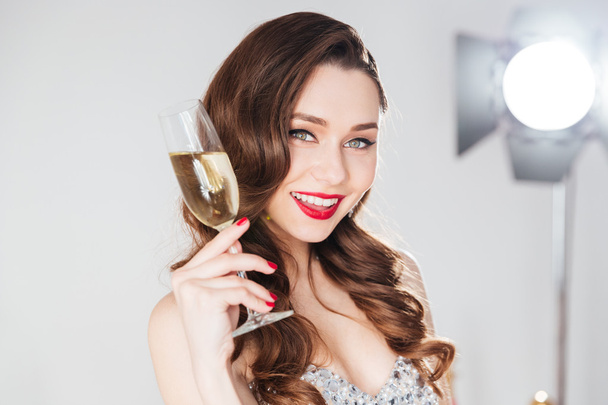 Woman holding glass of champagne  - Фото, изображение