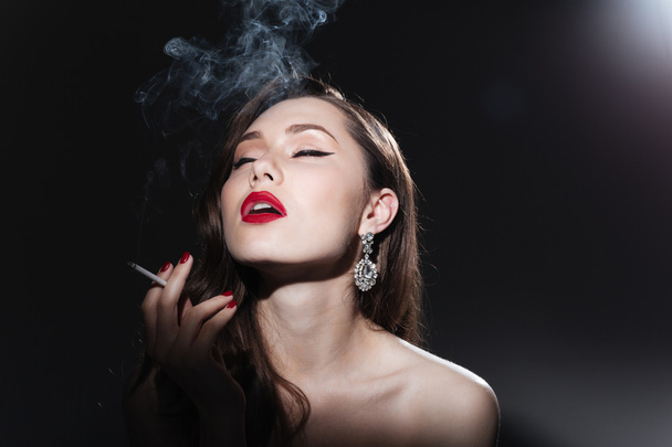 Beautiful woman smoking cigarette - 写真・画像