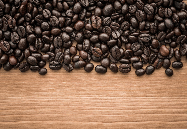 kahverengi kahve çekirdekleri ahşap tahta üzerinde arka plan - Fotoğraf, Görsel