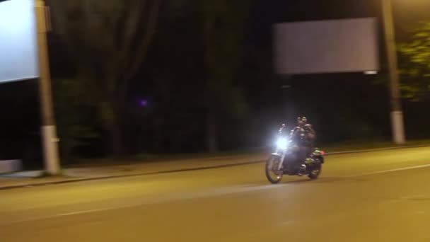 Biker on a custom motorcycle rides through the night deserted street. - Footage, Video