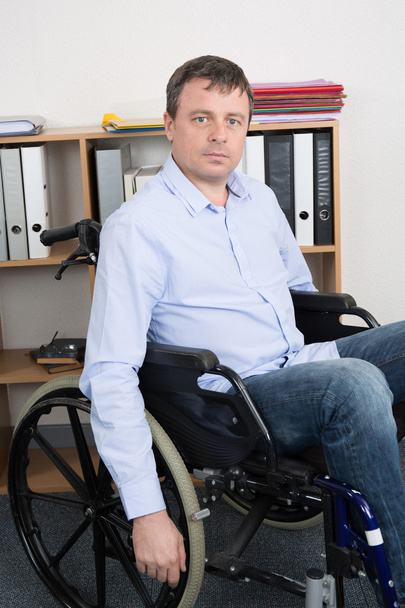 man in wheelchair in office is using his laptop,  - Foto, Imagem