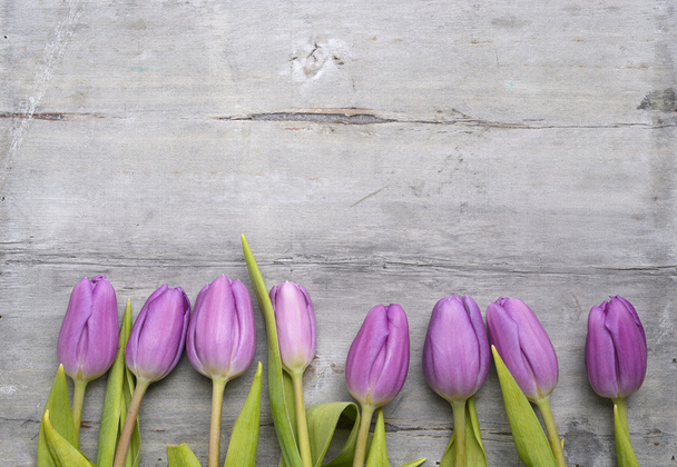 Oude grijs houten achtergrond met paars witte tulpen, snowdrop en crocus en lege kopie ruimte, lente zomer decoratie - Foto, afbeelding