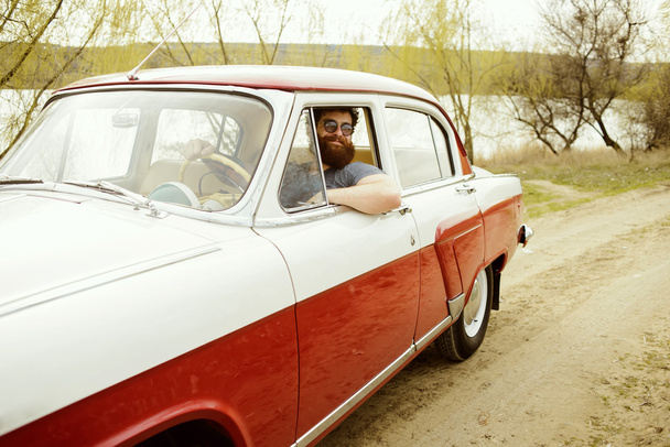 Bearded man behind the wheel of a retro car - Φωτογραφία, εικόνα