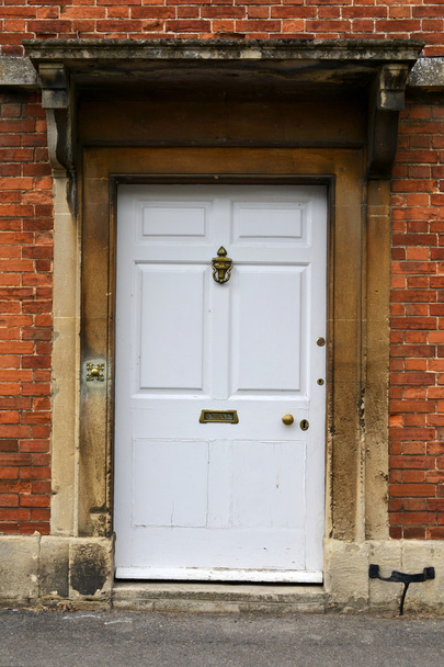 Fehér bejárati ajtót, egy vörös tégla magyar házban - Fotó, kép